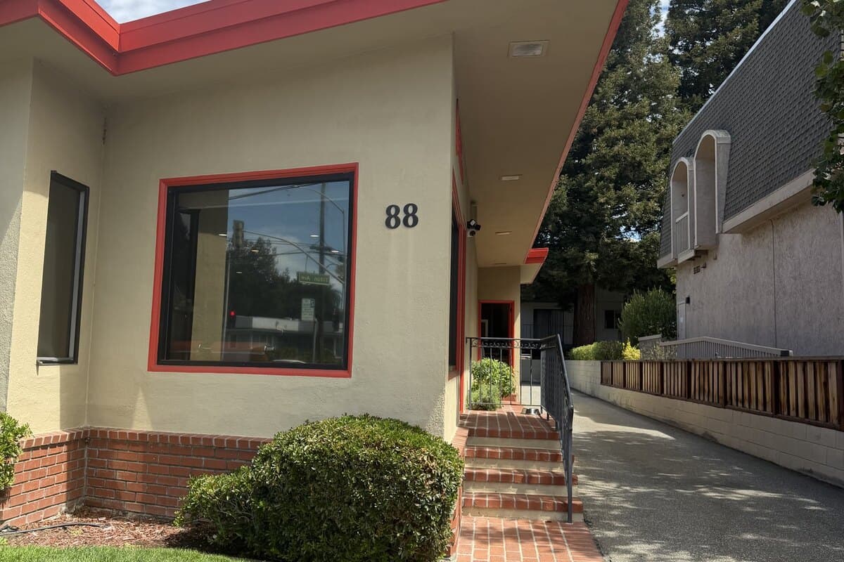 The front of the office building, number 88, with a brick path leading to a short flight of steps and a handrail.